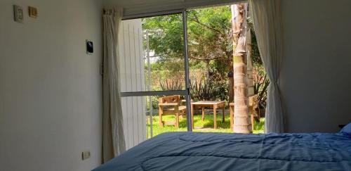 ABY Hotel في رامالو: غرفة نوم بسرير ونافذة كبيرة
