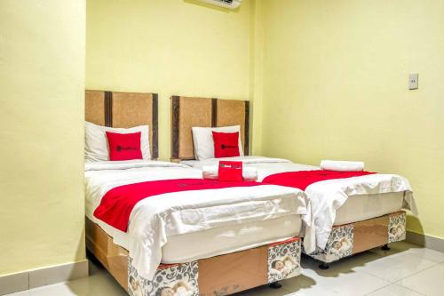 sypialnia z 2 łóżkami pojedynczymi i czerwonymi poduszkami w obiekcie RedDoorz @ Jalan Kapten Muslim Medan w mieście Medan