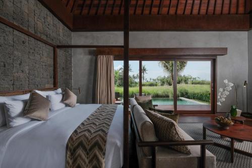 Schlafzimmer mit einem Bett und Poolblick in der Unterkunft The Garcia Ubud Hotel & Resort in Ubud