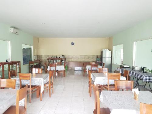 una sala da pranzo con tavoli, sedie e frigorifero di Komodo Boutique Hotel a Labuan Bajo