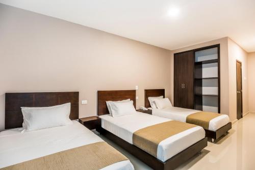 a hotel room with two beds and a window at Ribai Hotels - Barranquilla in Barranquilla