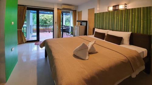 a bedroom with a large bed with two pillows on it at Supsangdao Resort in Ao Nang Beach
