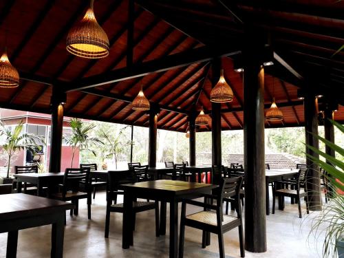 a restaurant with tables and chairs and lights at Goyambokka Guesthouse in Tangalle