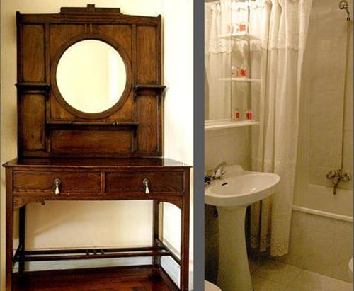 La salle de bains est pourvue d'un miroir rond et d'un lavabo. dans l'établissement Hostal Delfina, à Madrid