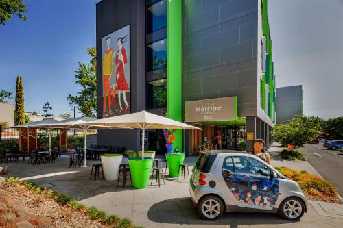 a small car parked in front of a building at Mercure Bendigo Schaller in Bendigo