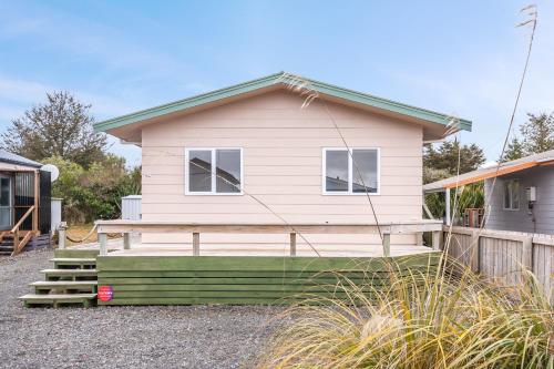 a small pink house with a porch and stairs at Fifteen B - National Park Holiday Home in National Park
