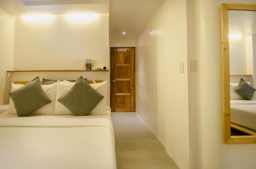 a bedroom with a bed and a mirror in a room at Zuzuni Boutique Hotel in Boracay