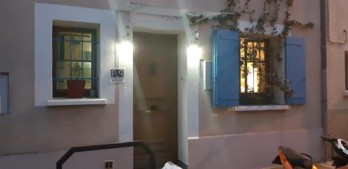 a room with two windows and blue shutters at Bed and Breakfast P&P Nîmes-Centre in Nîmes