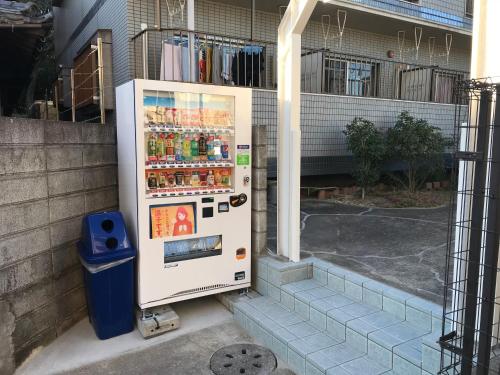 un frigorifero è seduto fuori da un edificio di ラ・ポート空港前201 a Fukuoka