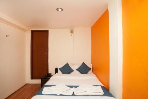 Schlafzimmer mit einem Bett mit blauen und orangefarbenen Wänden in der Unterkunft Hotel Green Horizon in Kathmandu