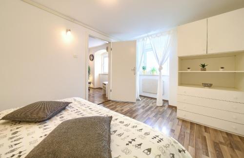 a white bedroom with a bed and a large window at Apartment City Center in Rijeka