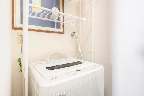 a bathroom with a sink and a washing machine at Uhome Ueno Apartment 4 in Tokyo