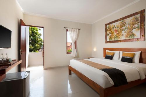 a bedroom with a large bed and a large window at Nesa Sanur Bali in Sanur