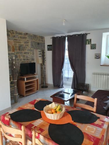 un salon avec une table avec un bol de fruits dessus dans l'établissement Gites de Line Marvie, à Surtainville