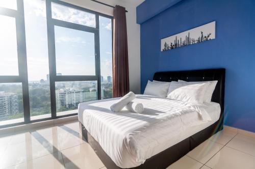 Schlafzimmer mit einem großen Bett mit blauen Wänden und Fenstern in der Unterkunft Centrus Soho Cyberjaya by IdealHub in Cyberjaya