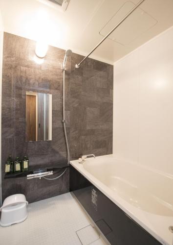 a bathroom with a shower and a sink at Nakamuraya Kyoto Enmachi Momiji in Kyoto