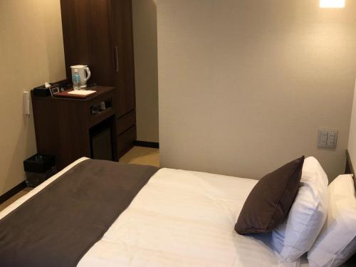 a bedroom with a bed with a pillow on it at Iwakuni Kokusai Kanko Hotel in Iwakuni