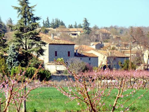 a small village in a field with pink flowers at Rev'ôthijol Vacances in Saint Alban Auriolles