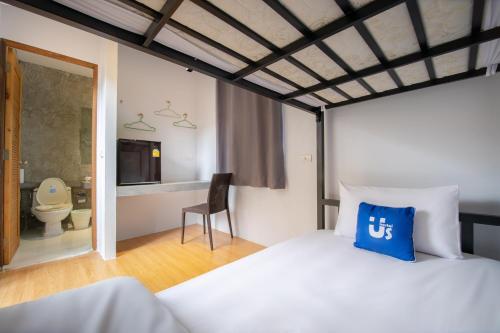 Un dormitorio con una cama con una almohada azul. en Us hostel samui, en Bophut 