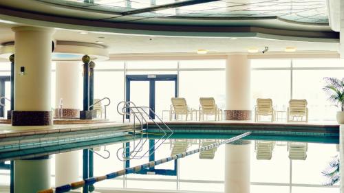 a swimming pool with chairs in a building at InterContinental Yokohama Grand, an IHG Hotel in Yokohama