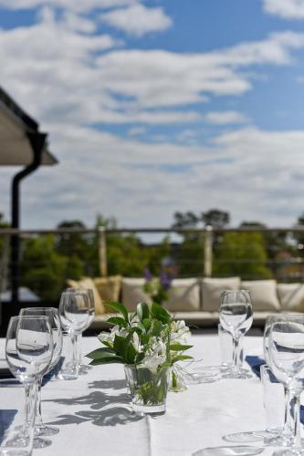 a table with wine glasses and a vase with flowers at Sands Hotell in Sandhamn