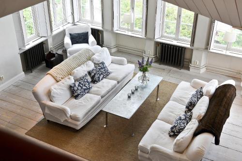 a living room with two white couches and a table at Sands Hotell in Sandhamn