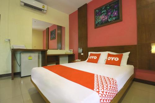 a bedroom with a large bed with two orange pillows at OYO 547 Happy Home in Bangkok