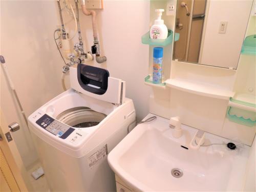 uma casa de banho com uma máquina de lavar roupa e um lavatório em 札幌市中心部大通公園まで徒歩十分観光移動に便利なロケーションs1111 em Sapporo