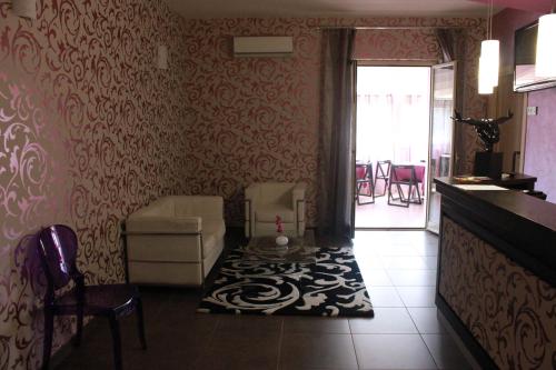 - un salon avec un canapé et une chaise dans l'établissement Hotel Vittorio Emanuele, à Floridia