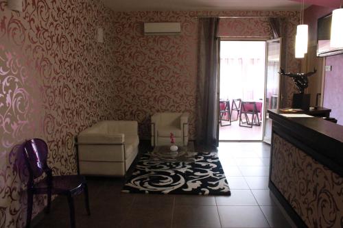 a living room with a couch and a chair at Hotel Vittorio Emanuele in Floridia