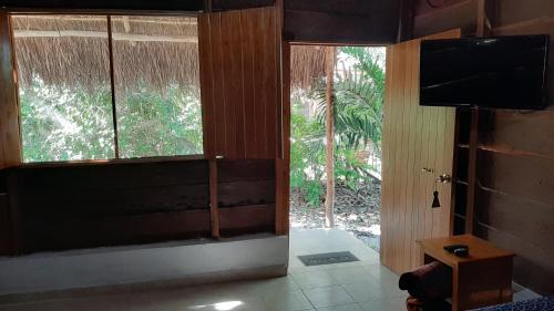 a living room with a large window and a television at Cabanas chaac calakmul in Xpujil