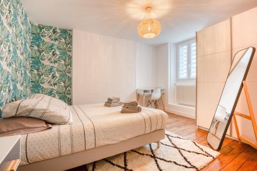 - une chambre avec un lit et un mur vert dans l'établissement Maison bourgeoise Haussmannienne - Gîtes de France, à Limoges