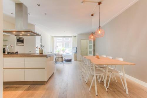 a kitchen and dining room with a table and chairs at Luxurious ground floor apartment with patio in Amsterdam