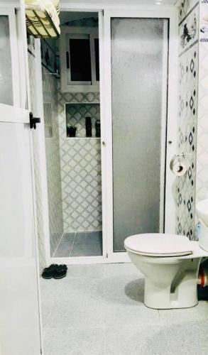 a bathroom with a toilet and a glass shower at Dar Sidi Mfedal in Chefchaouene