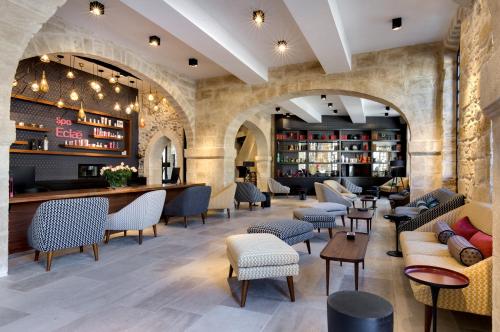 eine Lobby eines Restaurants mit Stühlen und Tischen in der Unterkunft Boutique Hôtel des Remparts & Spa in Aigues-Mortes