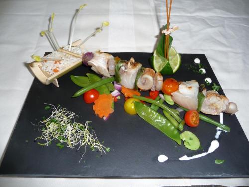 a plate of food with shrimp and vegetables on a table at Le Relais Des Chateaux Forts in Bitche