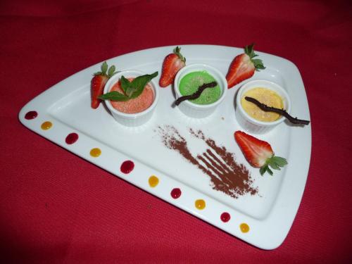 a plate of food with strawberries and dipping sauce at Le Relais Des Chateaux Forts in Bitche