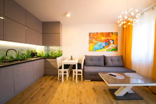 a kitchen and a living room with a couch and a table at Wyspa Uznam - Rondo Róży Wiatrów in Świnoujście