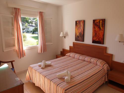 a bedroom with a bed with white towels on it at Apartamentos Piscis in Cala Blanca