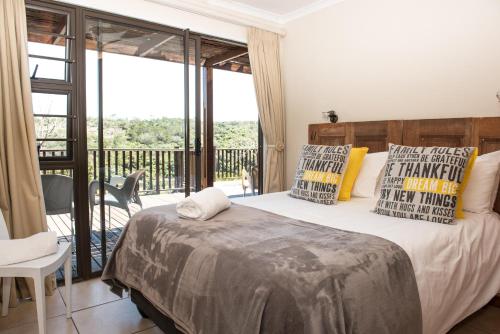 a bedroom with a large bed and a balcony at River Kaya in Kromriviermond