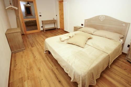 een slaapkamer met een groot bed en een houten vloer bij Cascina Bucolica in Alpignano