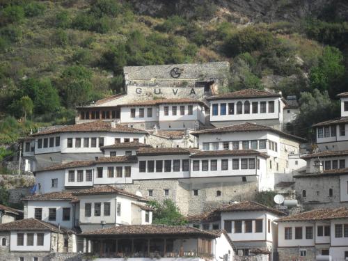 um grupo de edifícios brancos numa montanha em Guva Mangalem Hotel Restaurant em Berat