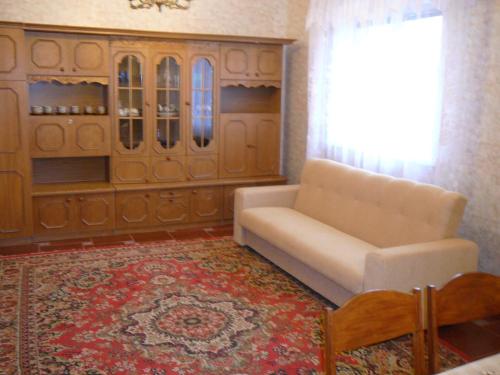 a living room with a white couch and a rug at Usadba Svetlye Rosy in Brest