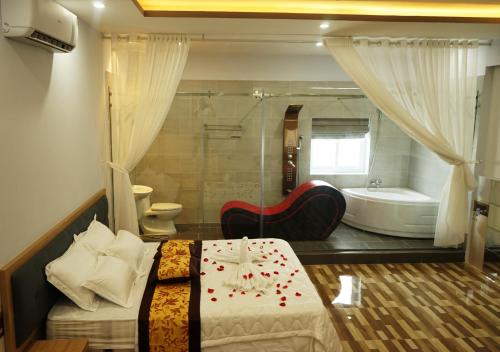 a bedroom with a bed and a tub and a bathroom at Tina 2 Hotel in Cái Răng