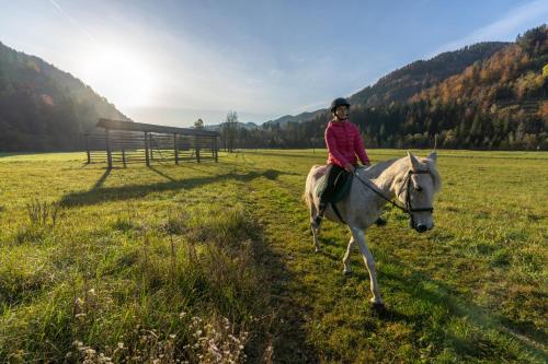 uma jovem a montar um cavalo num campo em Apartments Jon em Bled