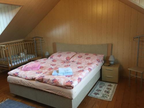 een slaapkamer met een bed met roze lakens en een wieg bij Apartman U Holica in Banská Štiavnica