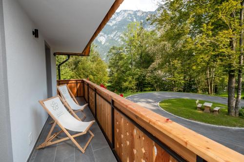 a balcony with two chairs and a view of a road at Bohinj Apartments Goldhorn Kingdom in Bohinj