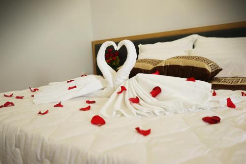 two swans are sitting on a bed with hearts at Tina 2 Hotel in Cái Răng