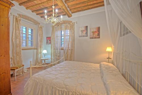 a bedroom with a large bed and a chandelier at Flavia by PosarelliVillas in Santa Maria del Giudice