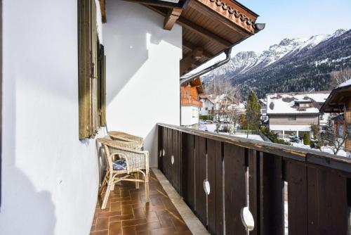 a chair sitting on a balcony with a view at Ciasa Christina in Moena